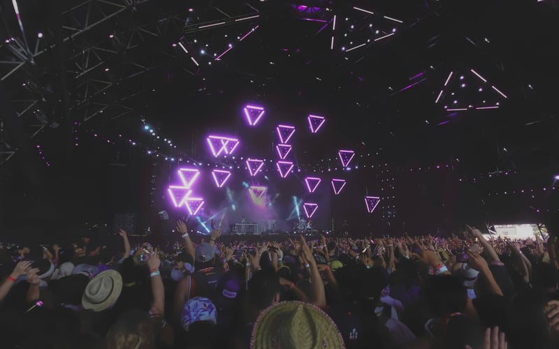 Festival crowd beneath neon stage lighting in the California Desert
